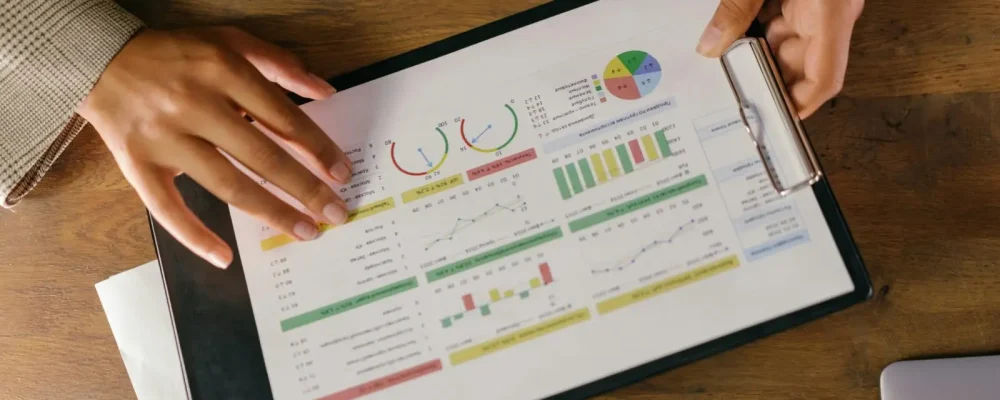 Top view of hands holding a financial report with colorful graphs and charts, ideal for business presentations.